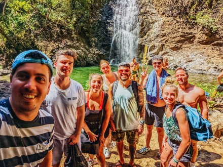 A group of people stood in front of a waterfall