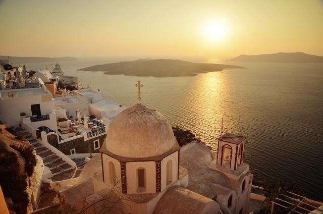 A view of Santorini's villas and the sea at sunset 