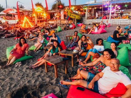 A group chilling on beanbags at the beach in Canggu, Bali, Indonesia 