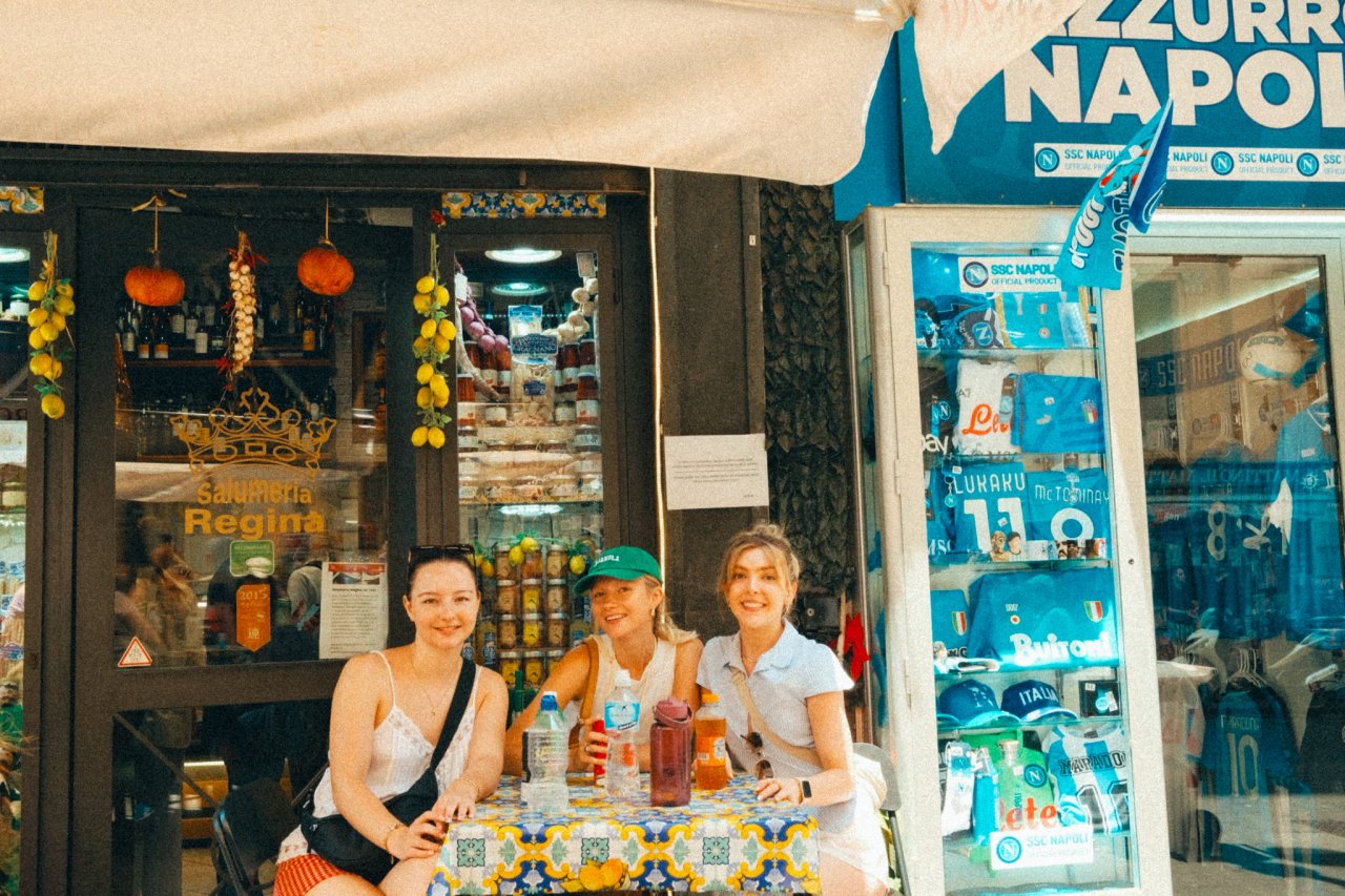 A group of young solo travellers on a group tour with TruTravels trying out some local food in Italy
